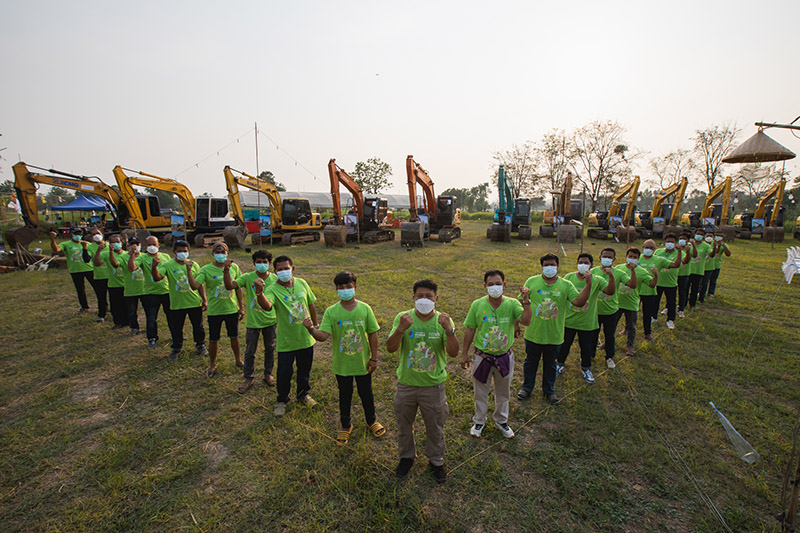 workers standing in front of construction machines